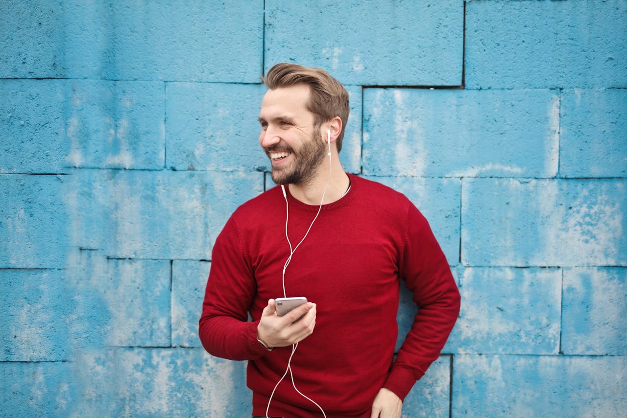 Submit Your Music. Pump It Up Magazine – indie artist smiling with headphones, ready to share his song for radio airplay and playlist placement