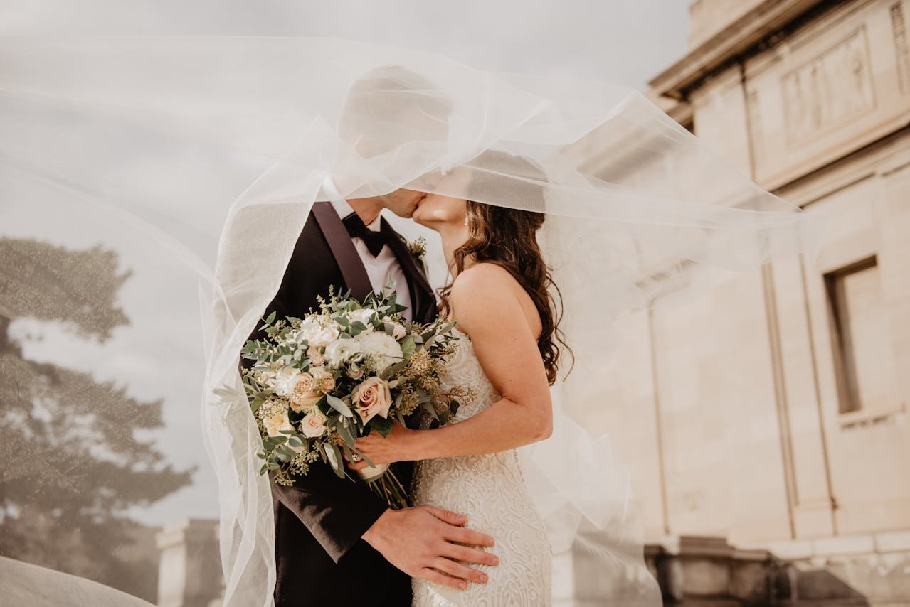 Romantic wedding moment with bride and groom kissing under the veil.