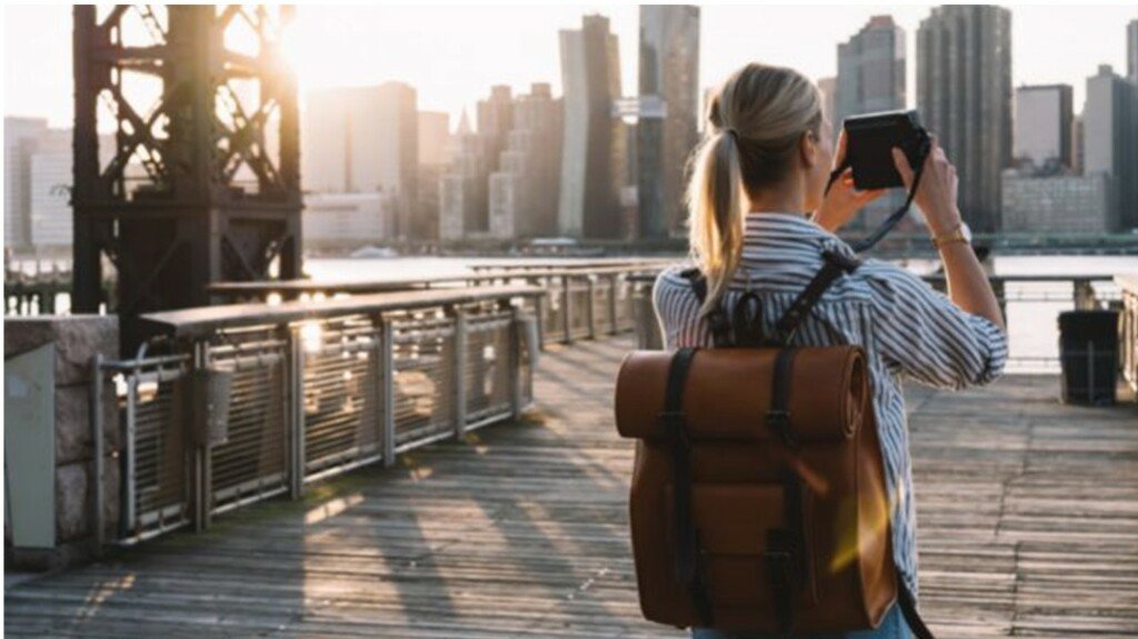 girl with bag back in new york city holding a camera
