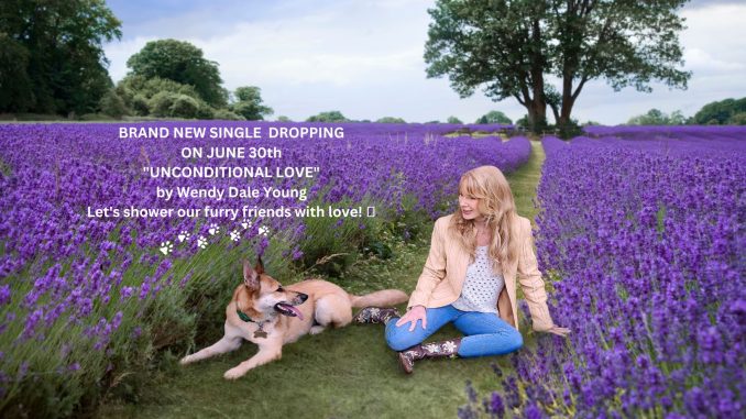 woman with her dog in sitting in green grass with purple flowers