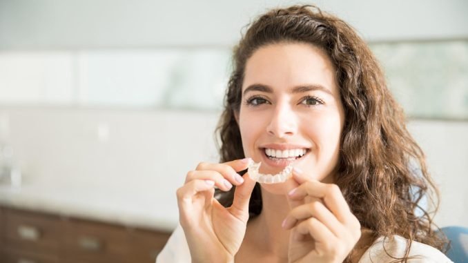 portrait-beautiful-patient-holding-orthodontic-retainers-dental-clinic