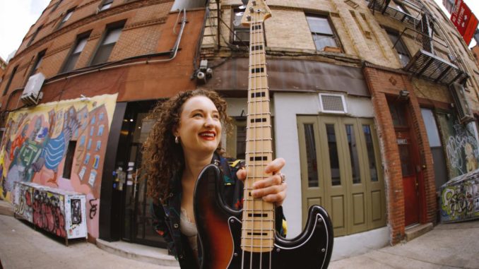 woman holding a bass guitar