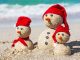 snow men at the beach with red had