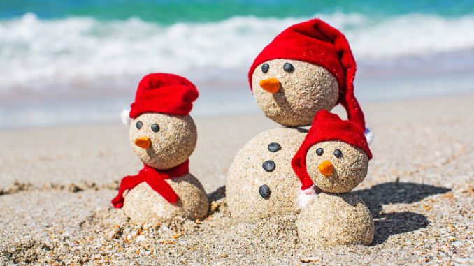 snow men at the beach with red had