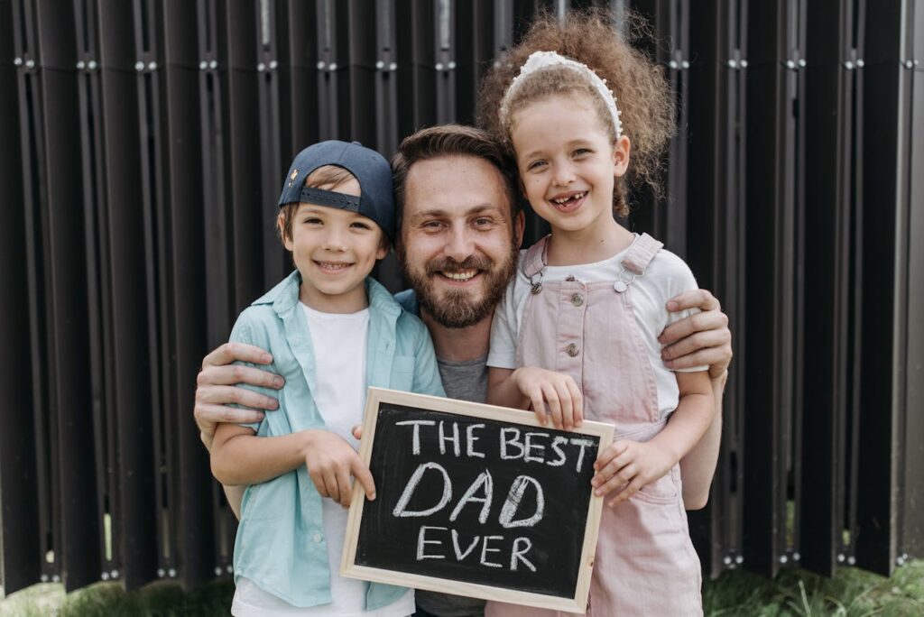 A father smiling with his children, representing fatherhood, emotional connection, and the importance of healing family relationships.