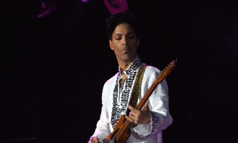 Prince playing guitar on stage