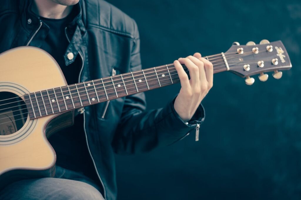 music promotion for artists – acoustic guitarist in leather jacket