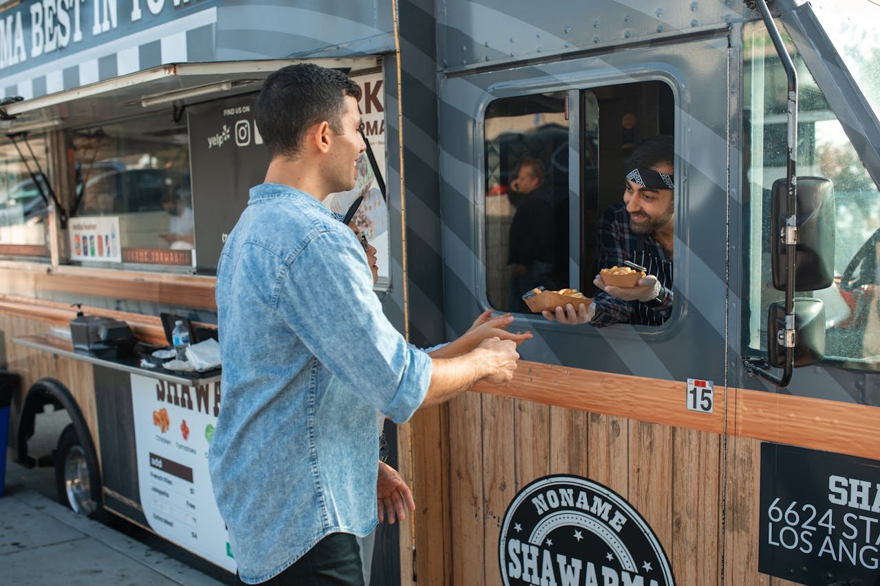 Man reducing anxiety by enjoying fresh shawarma from a friendly vendor at a Los Angeles food truck festival.