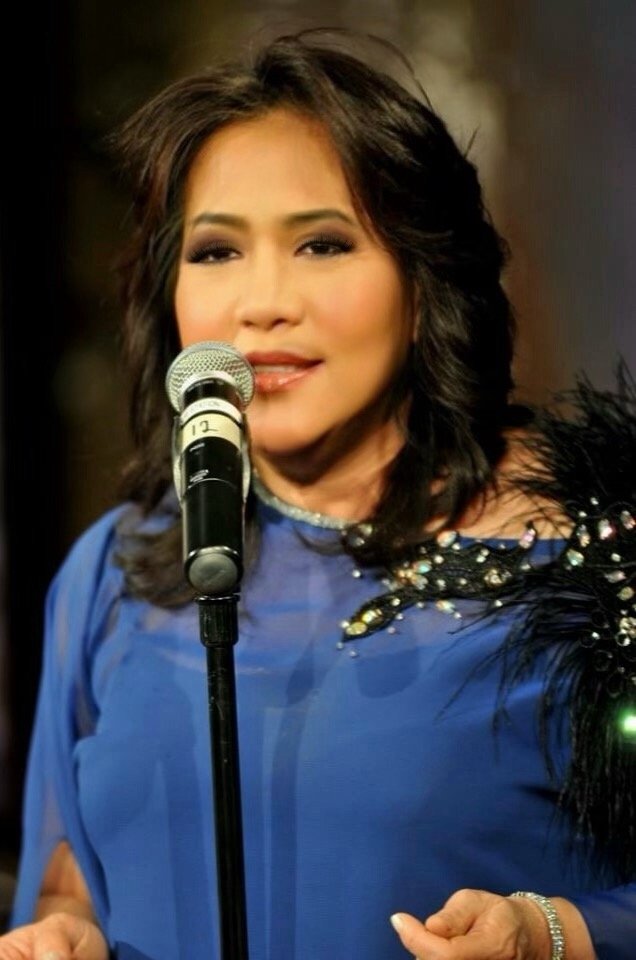 a woman in a blue dress with a microphone