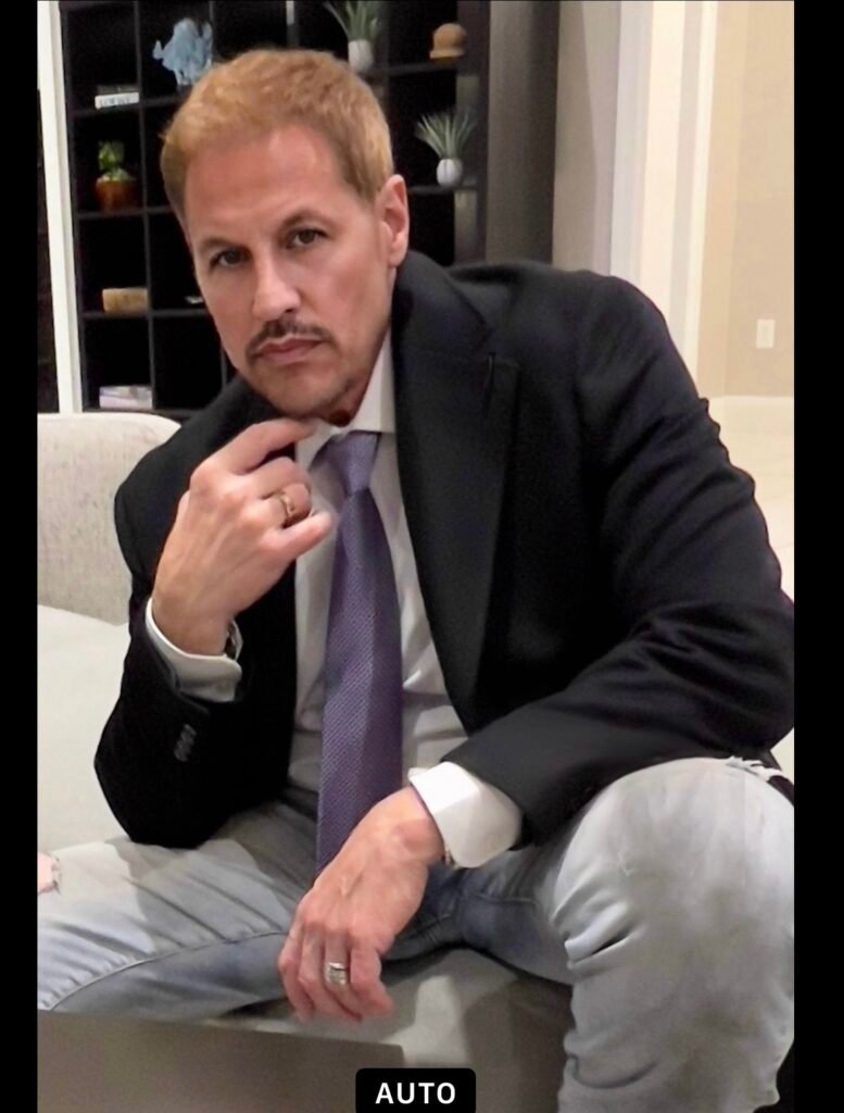 Michael Cates seated in a suit and tie, looking confidently into the camera