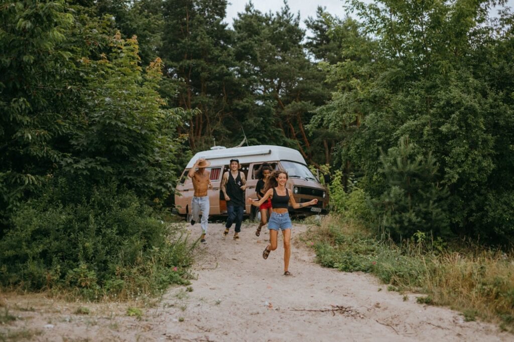 3-women-and-2-men-standing-on-dirt-road-near-white-van