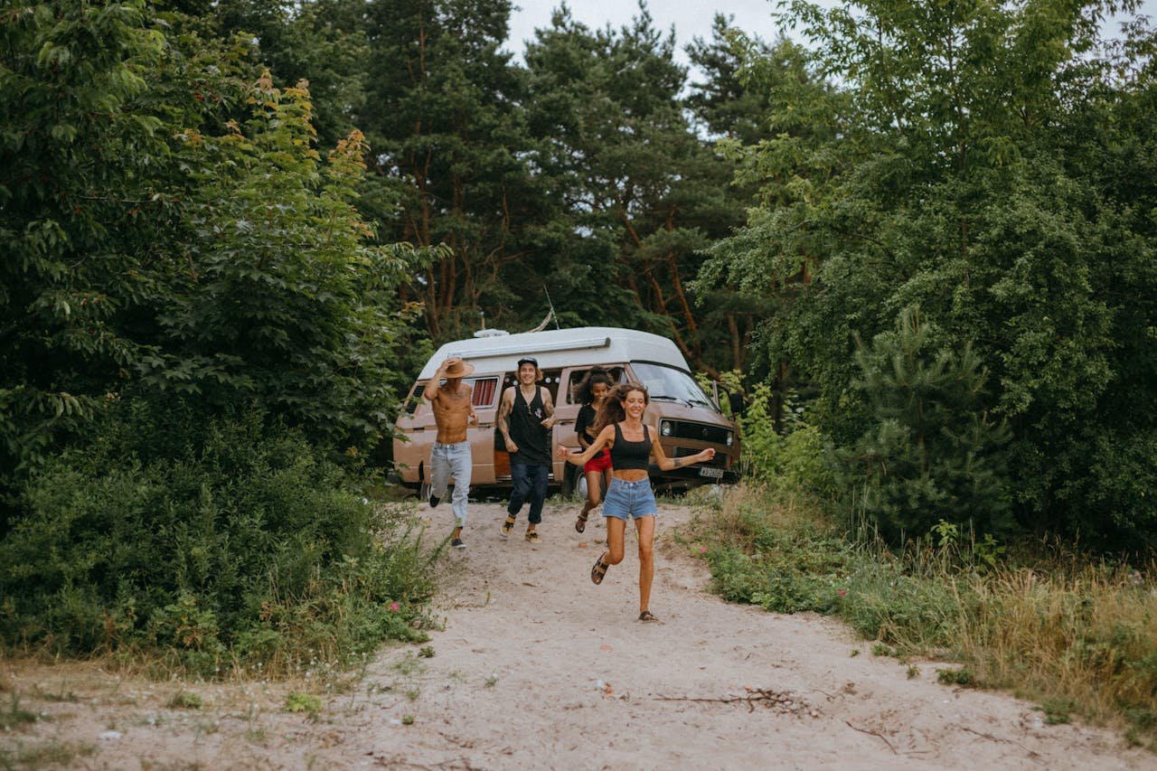 3-women-and-2-men-standing-on-dirt-road-near-white-van
