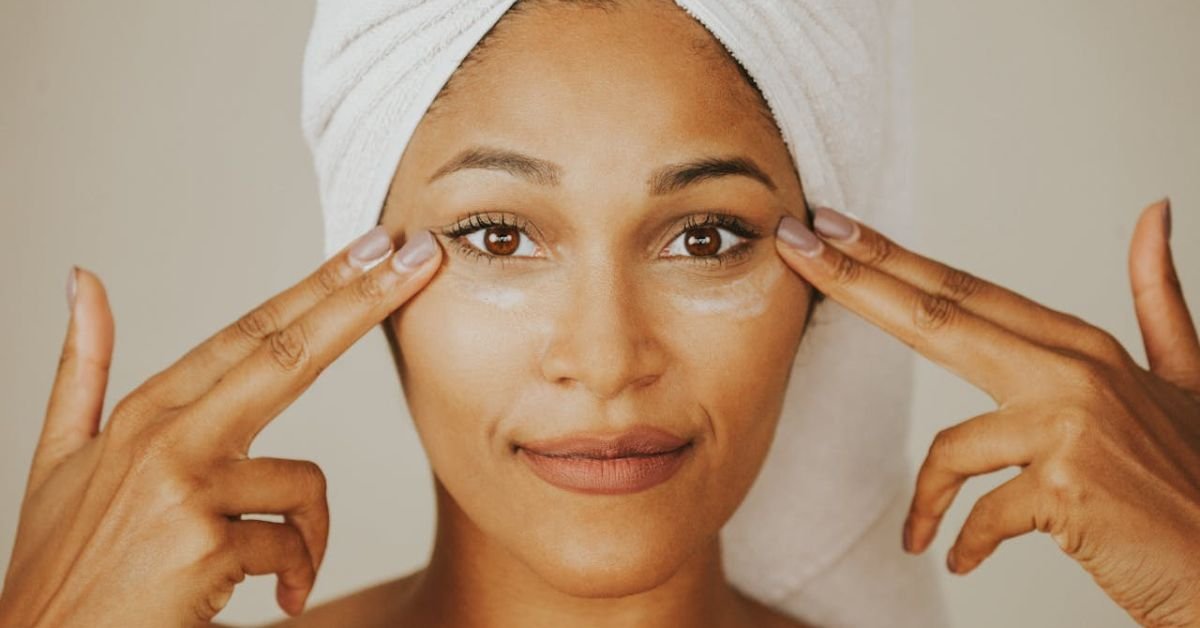 Woman applying under-eye cream as part of her best anti-aging secrets skincare routine.