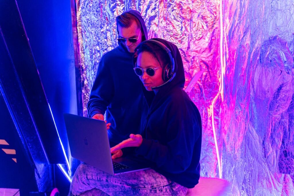 Creators using laptops in a futuristic neon workspace, representing Google Veo 3 AI video technology.