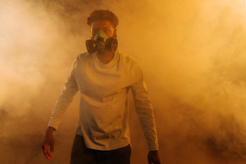 Man wearing a gas mask surrounded by smoke, symbolizing protection from toxic energy and spiritual danger.