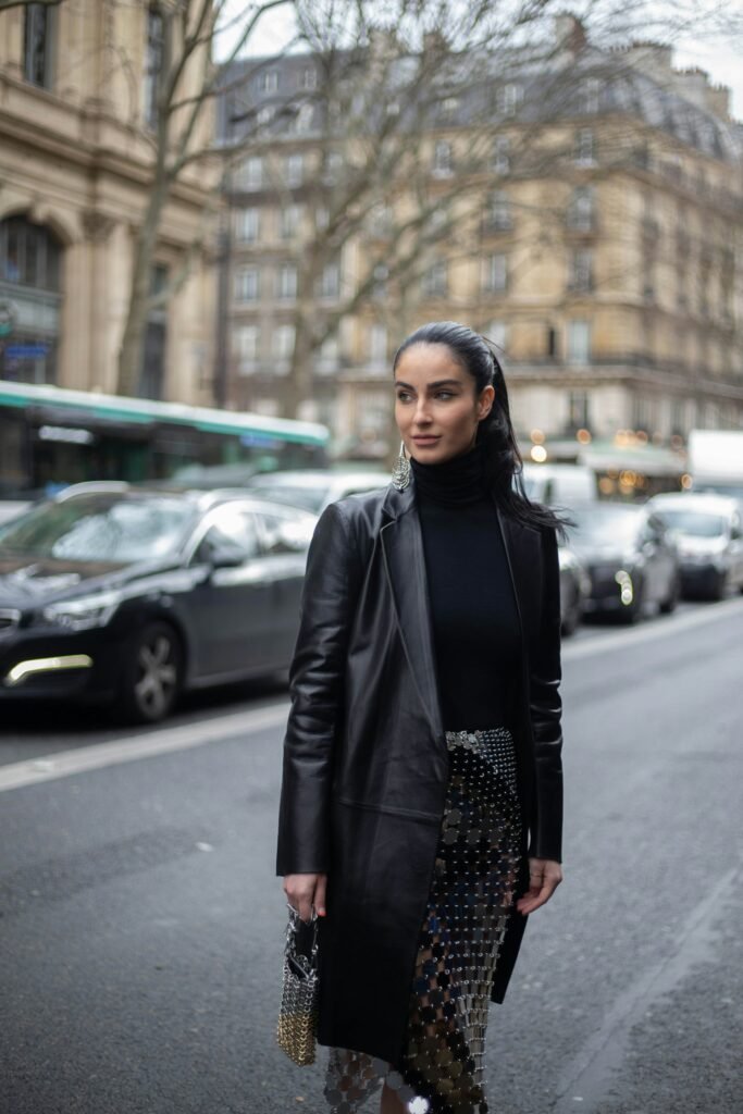 Black leather blazer layered over basics, Paris street-style portrait.