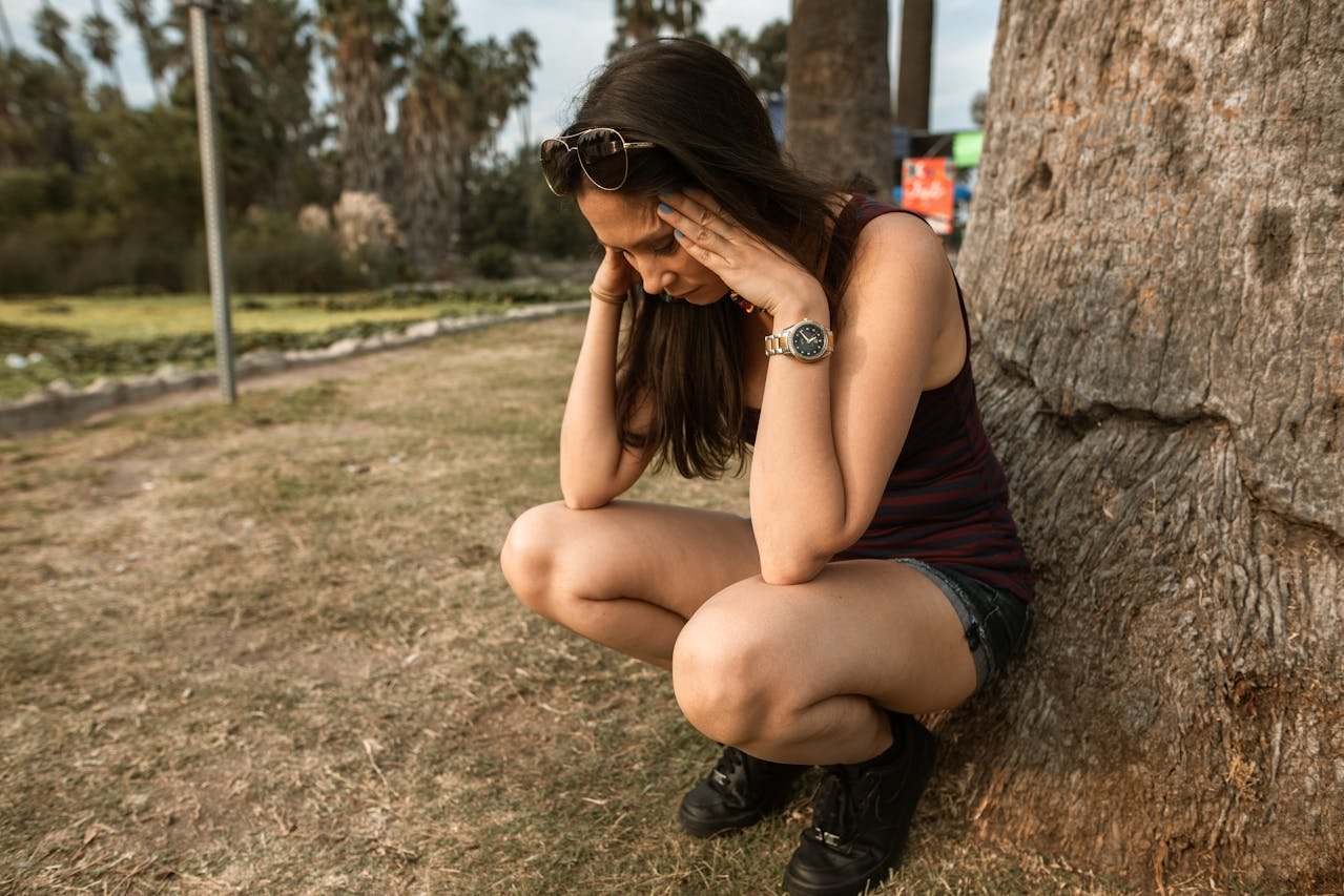 woman-crouching-while-her-hands-are-on-her-head-chronic stress
