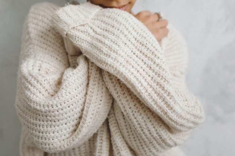 Close-up of a cozy natural wool sweater representing high frequency fabrics and positive energy fashion.