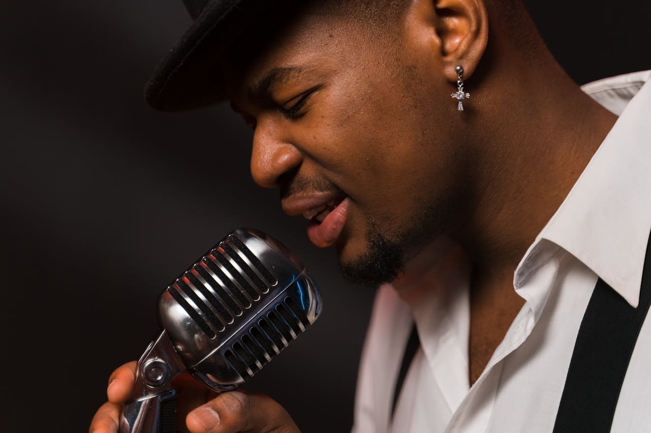 Indie artist performing into a microphone, representing how musicians get discovered in 2025 through Spotify playlists, radio, and magazine features.
