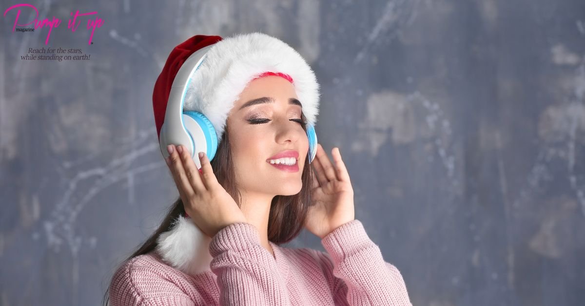 Beautiful woman wearing Santa hat and headphones smiling while listening to Christmas music – Best Christmas Songs 2025 playlist banner