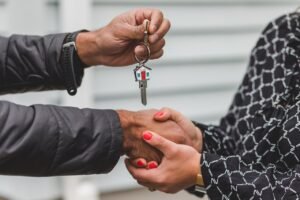 Hands exchanging house keys symbolizing successful homeownership for first-time buyers