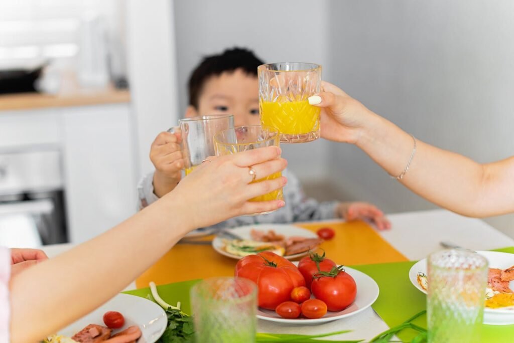 Women and boy toasting with juice for their health.