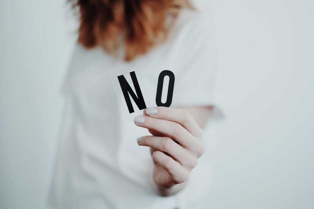 Person holding letters spelling 'NO' representing setting healthy emotional boundaries against passive-aggressive comments