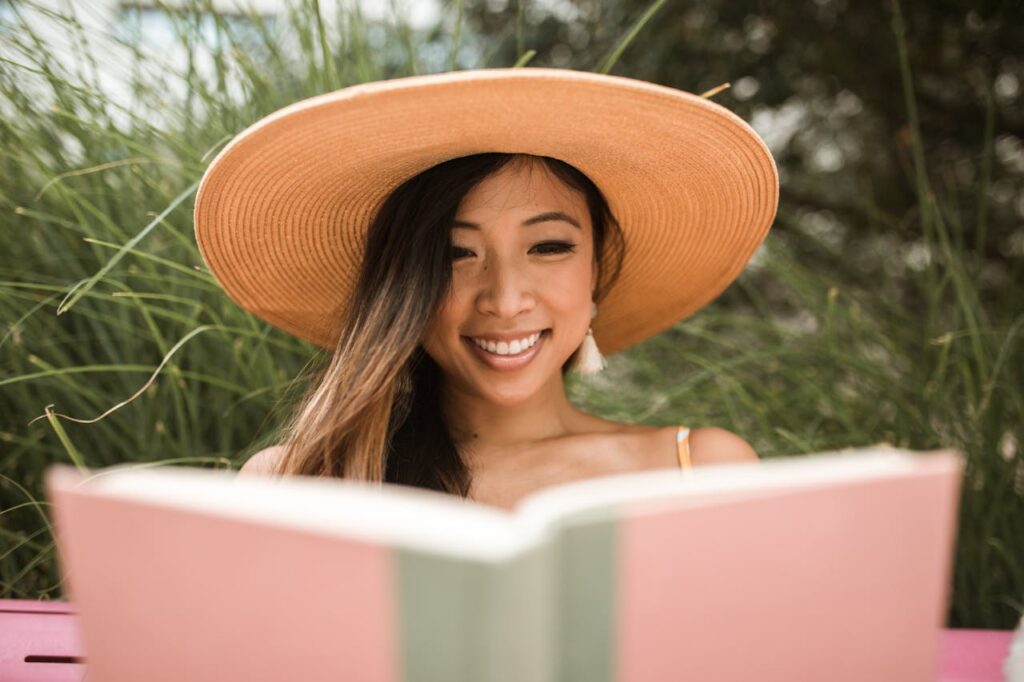 best books for a healthy lifestyle A woman enjoying a peaceful moment while reading a book outdoors, representing how the best books for a healthy lifestyle can support mental health, emotional well-being, and mindful living.