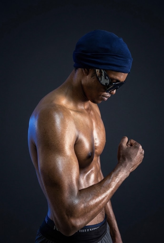 YSM muscular portrait looking down with clenched fist showing strength discipline and focus