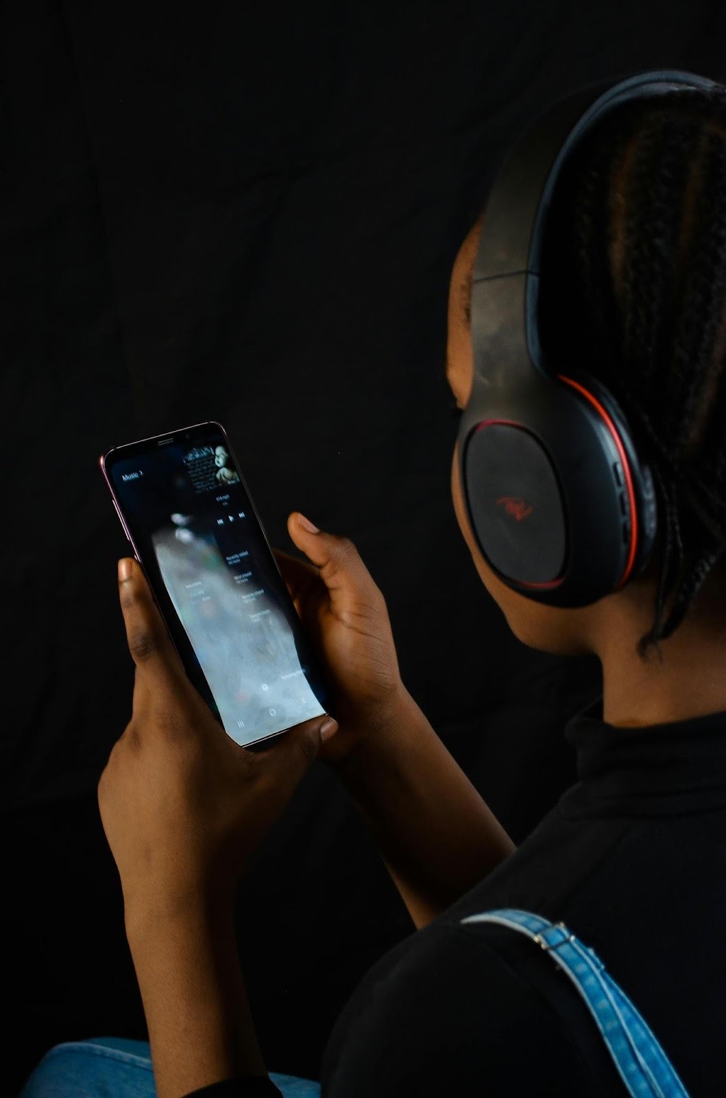 Person using phone with headphones and tech tools