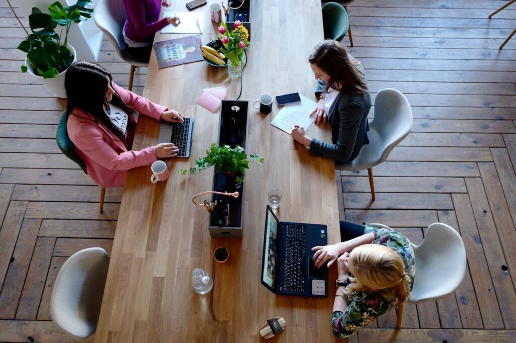 indie brands - hree-woman-sitting-on-white-chair-in-front-of-table