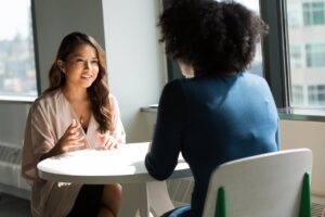 Women Business professionals introducing themselves during a networking conversation in a modern office setting