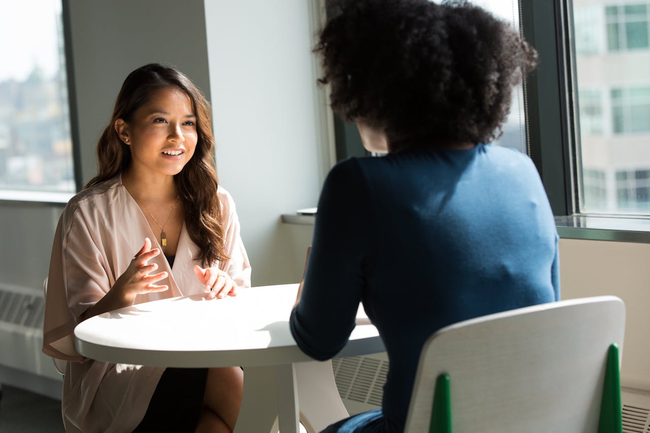 Women Business professionals introducing themselves during a networking conversation in a modern office setting