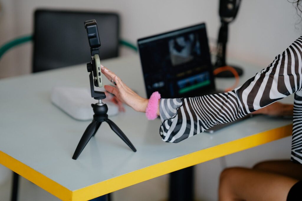 Content creator using a smartphone and laptop setup for AI-powered social media, video creation, and online side hustles in 2026.