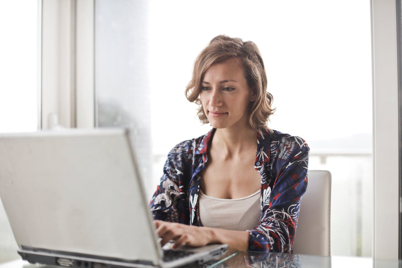 Woman working from home on a laptop using AI tools to build online income in 2026.