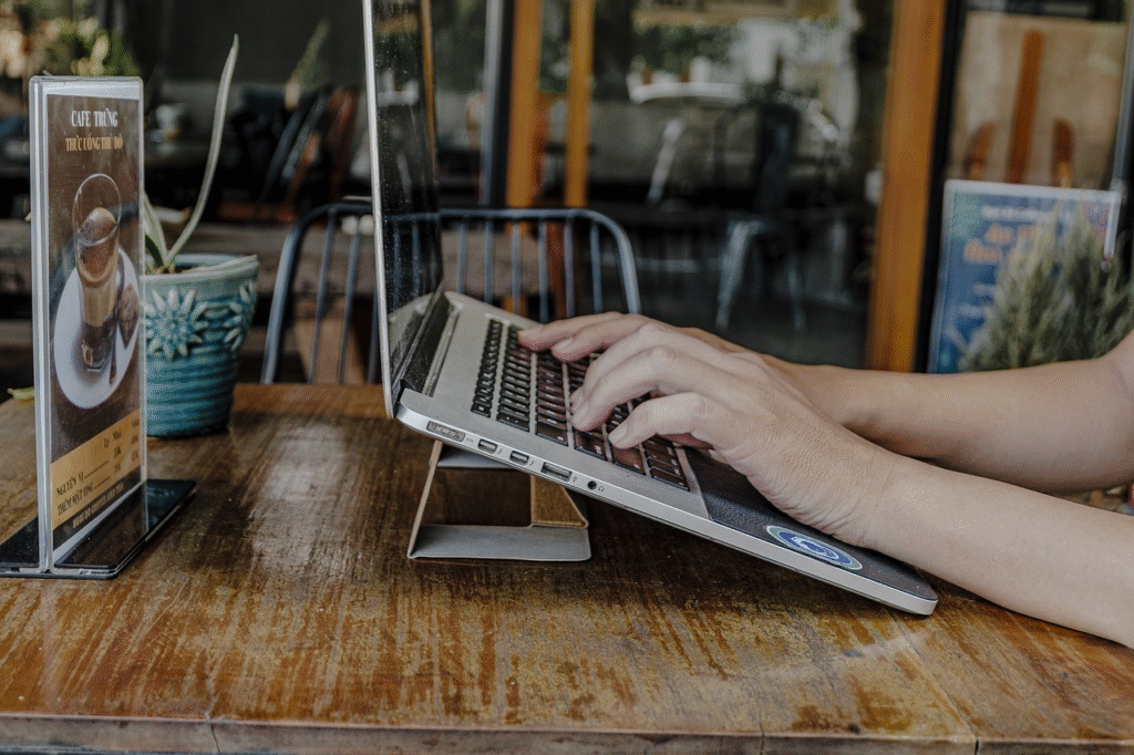 Person typing on laptop, tech system at café