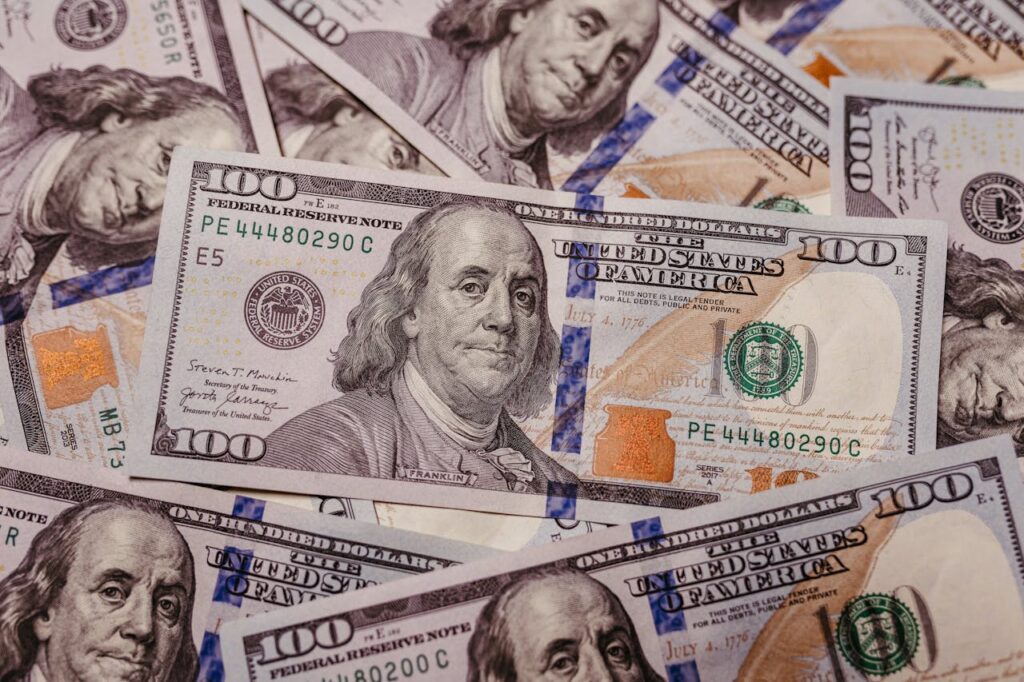 Stack of hundred dollar bills representing AI side hustles, online income opportunities, passive income, and making extra money in 2026.