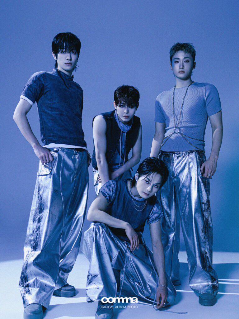K-pop group COMMA featuring their single "Radical." The four members appear in a dark blue-toned editorial design 
