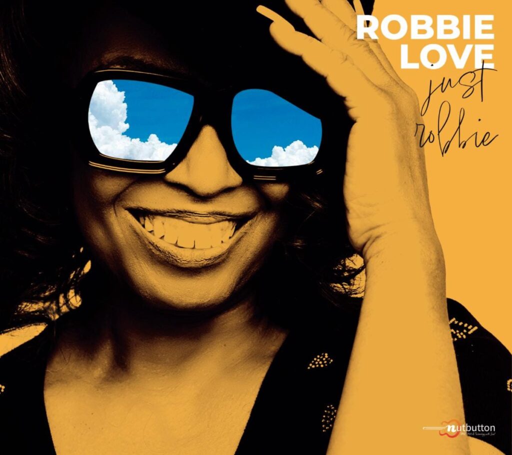 Album cover for Robbie Love's JUST ROBBIE EP featuring the soulful R&B singer wearing oversized sunglasses with blue sky reflections and a warm golden artistic design.