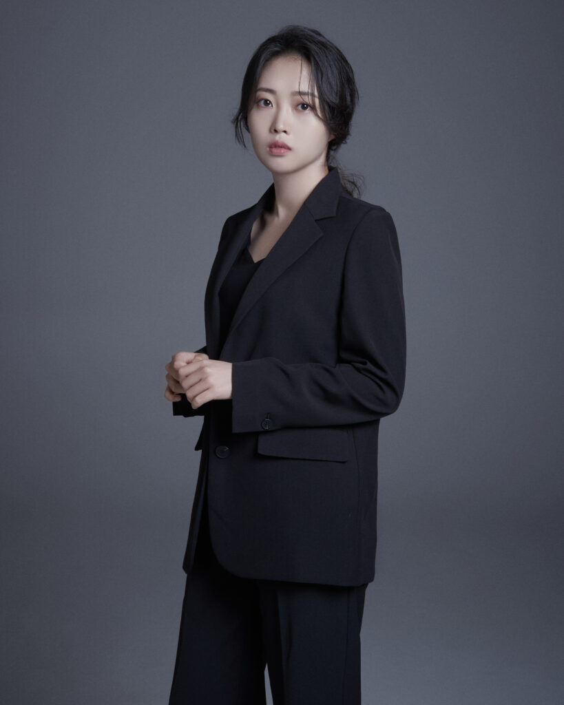 Kim Sunnyeong standing portrait in elegant black suit, showcasing the grace, confidence, and emotional depth behind her debut Korean storytelling single "Named Hyung."