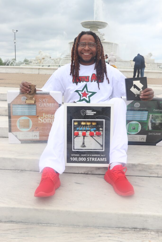 SATGAME Detroit rapper holding music awards and 100,000 streams plaque – Billboard charting independent hip-hop artist.