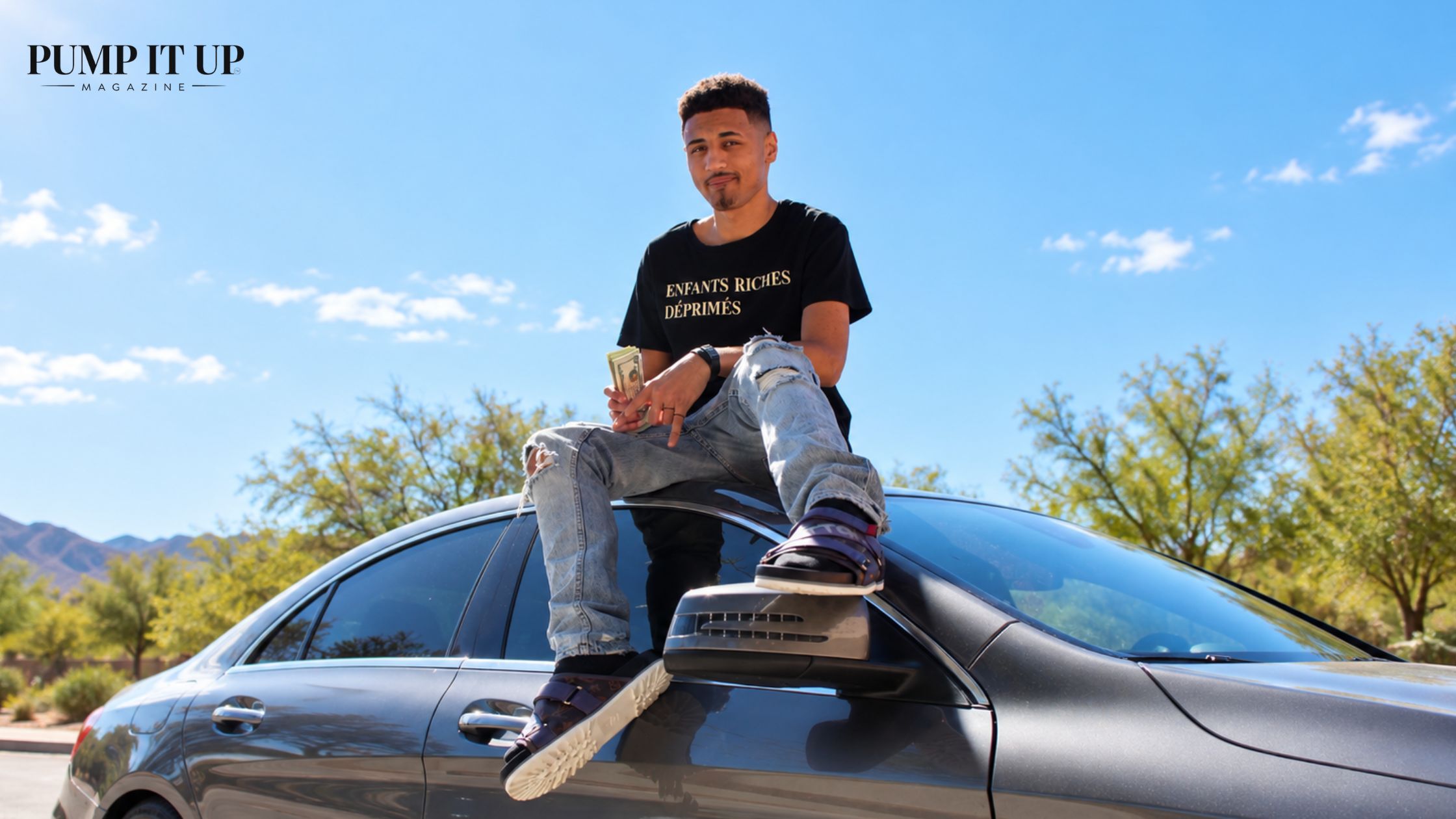 CJ sitting on a luxury car during a SUPERMODELS UNLIMITED fashion photo shoot