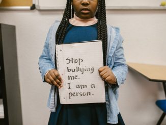 anti bullying sign holding by black little girl