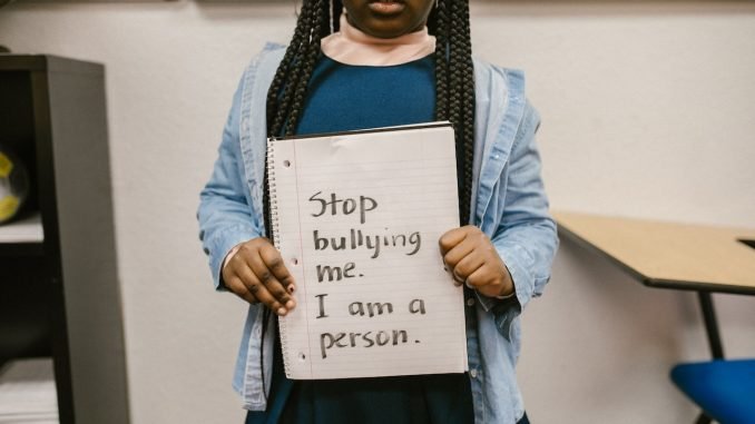 anti bullying sign holding by black little girl