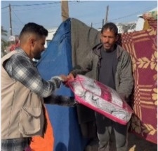 Abdullah Qudaih distributing humanitarian aid to a displaced family in Gaza.